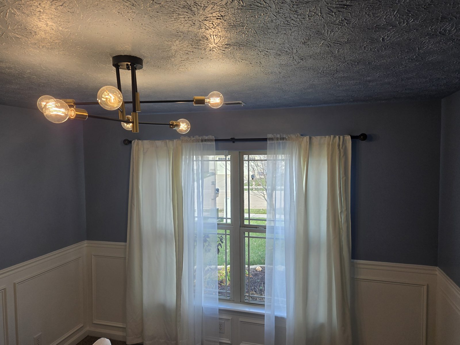 Finished Lafayette bedroom with curtains hung and the wainscoting complete
