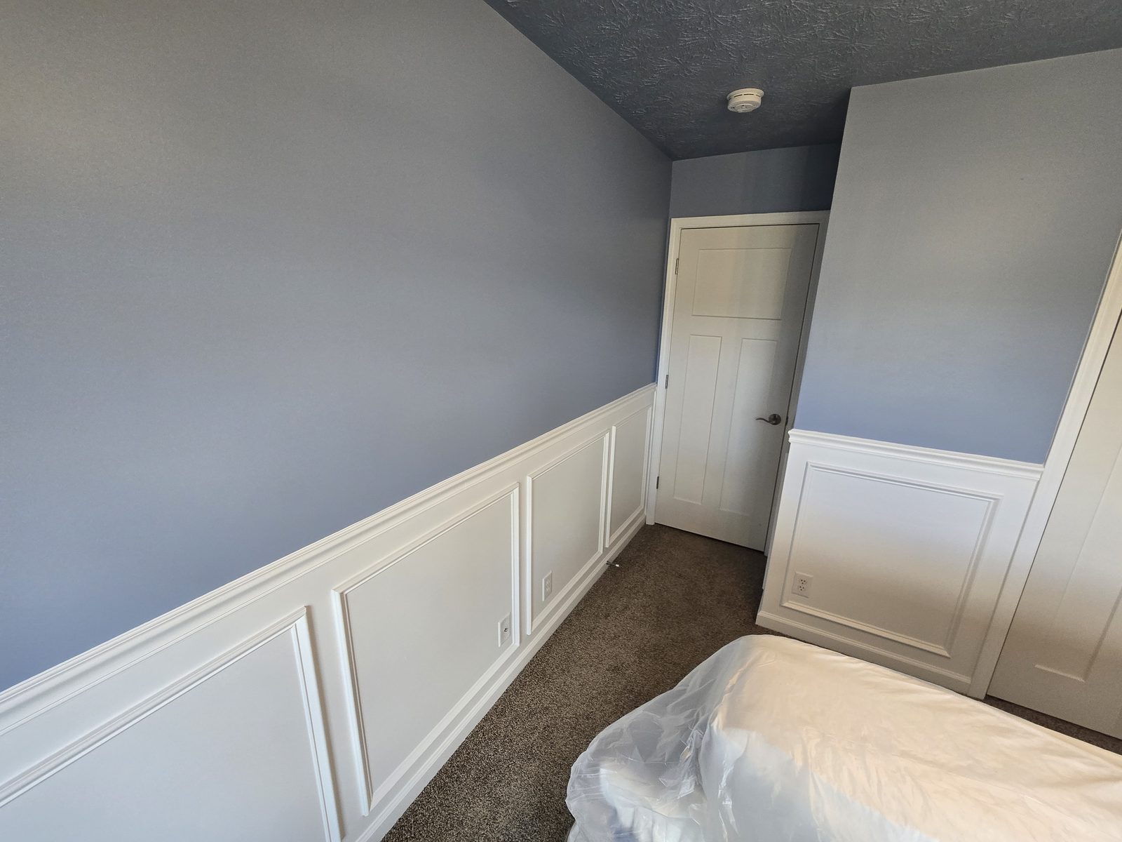Picture frame panels running the length of a Lafayette bedroom wall