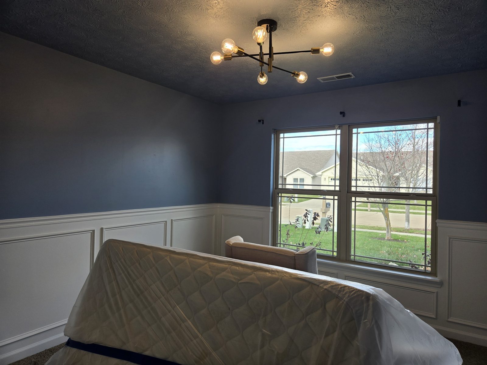 Picture frame wainscoting carried under the window in a Lafayette bedroom