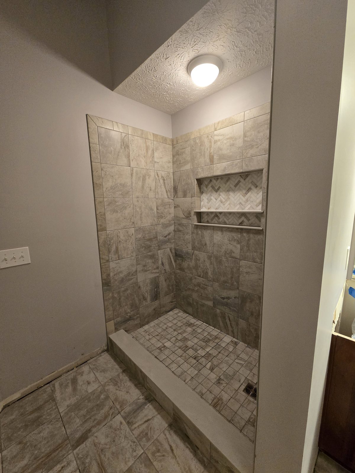 Tiled shower niche and mosaic floor in a Lafayette bathroom