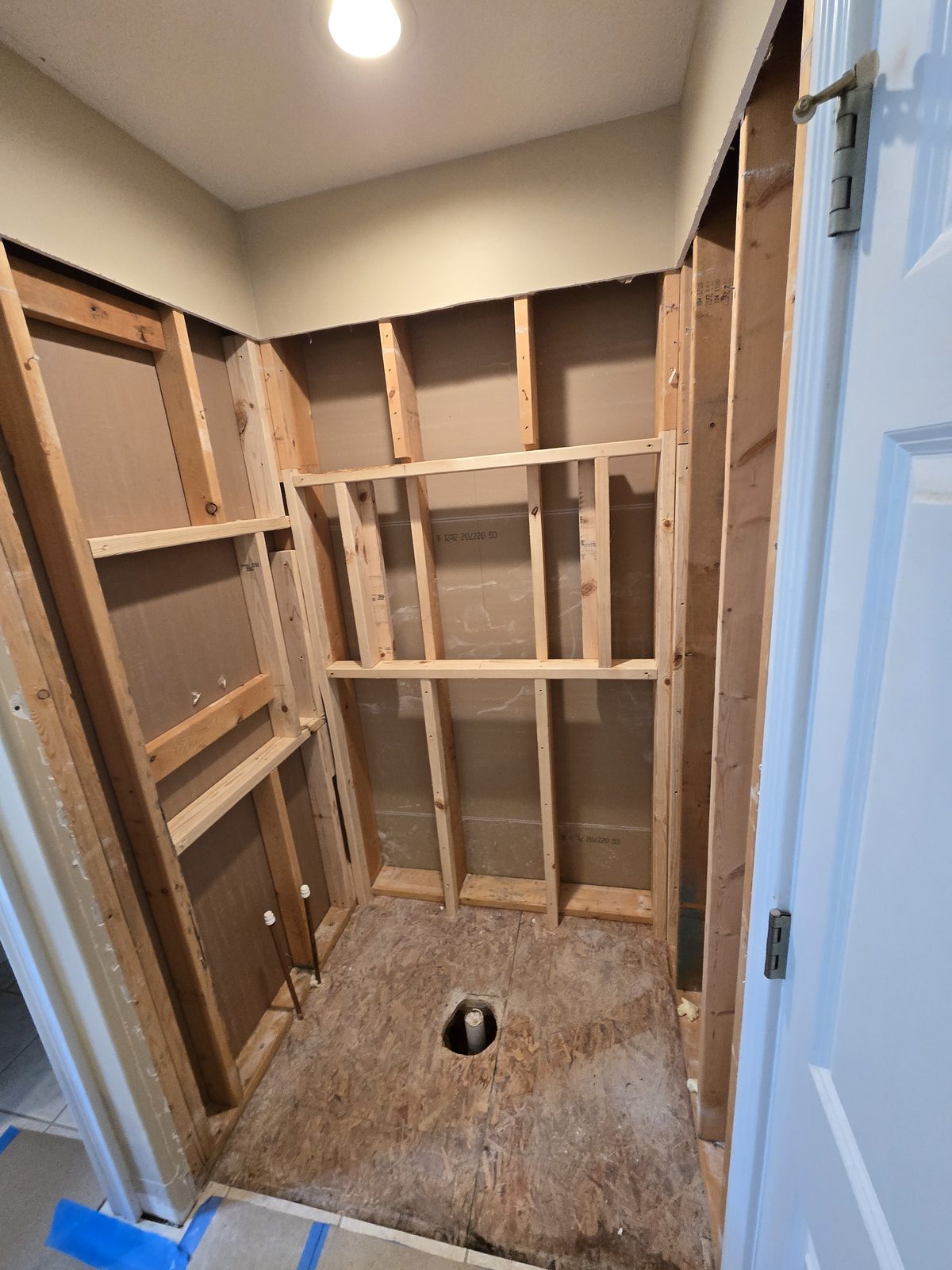 Open shower framing and the damaged original subfloor in a West Lafayette bathroom