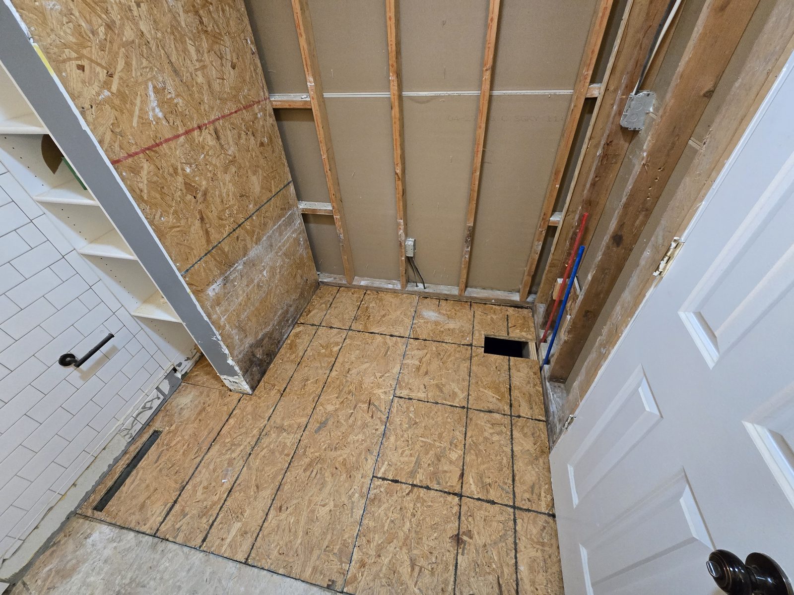 New subfloor sheathing glued and laid across a West Lafayette bathroom after water damage